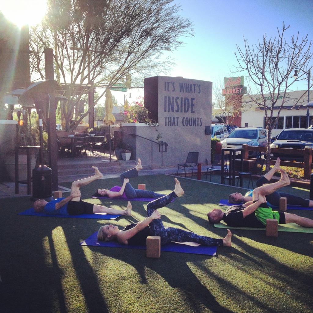 Participants lying on yoga mats on the Postino East lawn